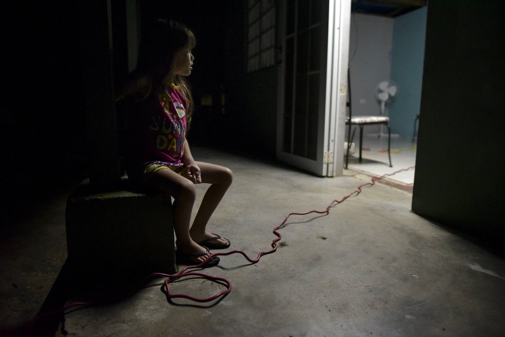 Melanie Oliveras González, de seis años, sentada en la terraza de su casa en Barrio Patrón, Morovis, Puerto Rico. Su casa perdió el tejado y la mayoría de sus pertenencias al paso del huracán María, y todavía no tienen suministro eléctrico. Foto: Carlos Giusti / AP.