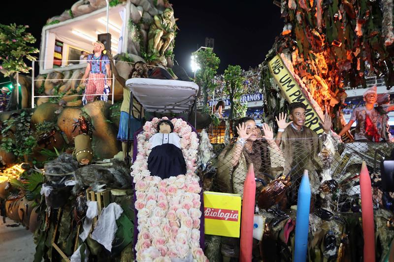 Integrantes de la escuela de samba del Grupo Especial Beija Flor, hace una representación de la violencia en Rio de Janeiro en Rio de Janeiro con ataúd con estudiante muerto y un policia arriba tiroteado hoy, domingo 12 de febrero de 2018, en la celebración del carnaval en el sambódromo de Marques de Sapucaí en Río de Janeiro (Brasil). EFE/ Marcelo Sayão