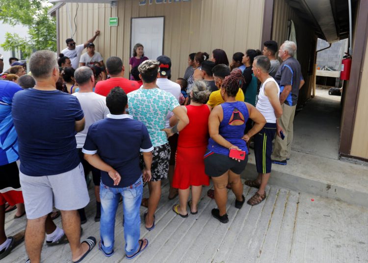 Human rights lawyer Jennifer Harbury (center, in the background) instructs several migrants how to process asylum requests in Reynosa, Mexico, on May 1, 2019. Photo: Eric Gay/AP.