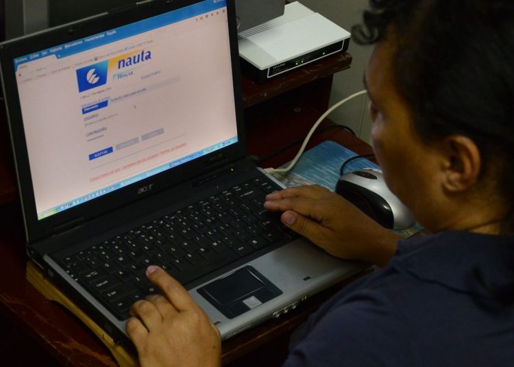 A man surfs the Internet from his home on Amargura and Mercaderes streets, one of the sites selected for the pilot test for home Internet connection, in the neighborhood of Old Havana, in December 2016. Photo: Joaquín Hernández / Xinhua.