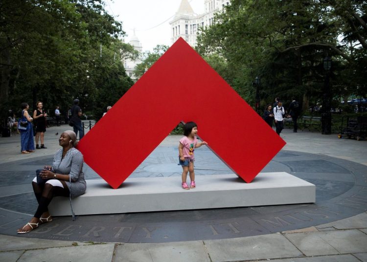 Passers-by interact with a work of the first great exhibition of outdoor sculptures by Cuban artist Carmen Herrera in New York. Photo: Kena Betancur / EFE.