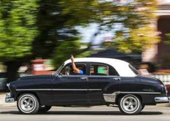 A taxi driver with a private license uses his hand to notify potential clients that he will turn right in Havana. Photo: Desmond Boylan / AP / Archive.