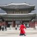A woman with her mouth covered by a mask walks in front of Gyeongbokgung Palace, one of South Korea's best known monuments in Seoul, on February 22, 2020. (AP Photo/Lee Jin-man)