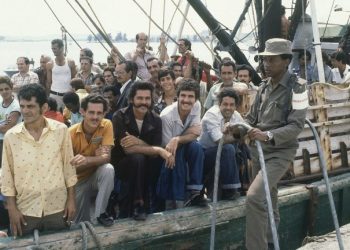 A Cuban soldier guards a ship in the port of Mariel on April 23, 1980, while people on board wait to sail to the United States. Photo: Jacque Langevin / AP.