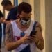 A Cuban checks his cell phone in Havana wearing a facemask as a protection measure against the COVID-19 pandemic. Photo: Otmaro Rodríguez.