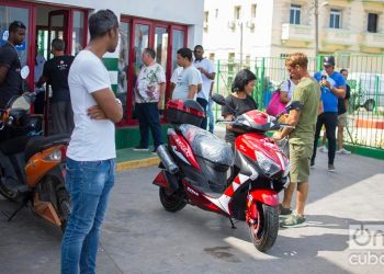 A couple by an electric motorcycle purchased at El Tángana gas station, in Havana, on October 28, 2019. Photo: Otmaro Rodríguez.