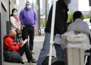 A person fills out a job application during a Seattle job fair for the new line of masked. Photo: Ted S. Warren/AP.