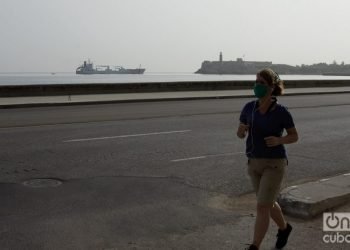 A woman jogs in Havana, wearing a mask as a protection measure against the coronavirus pandemic. Photo: Otmaro Rodríguez