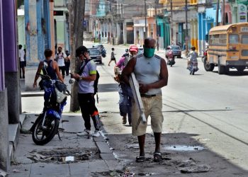 Several people walk down a street in Havana after the passage of Tropical Storm Laura. Photo: Ernesto Mastrascusa/EFE.