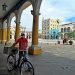 A man with a mask walks his bicycle through a square in Old Havana. Photo: Ernesto Mastrascusa/EFE.