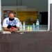 A clerk wearing a mask checks his mobile phone, after the relaxation of restrictions due to COVID-19 in Havana. Photo: Otmaro Rodríguez.