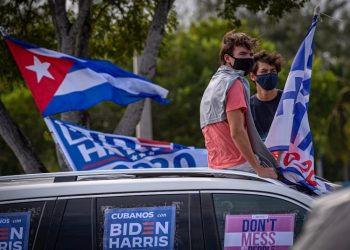 Some young people listen to the speech of former United States President Barack Obama, sitting on the roof of a car decorated with posters that say “Cubans for Biden Harris,” during a rally in support of Democratic presidential candidate Joe Biden, in the Biscayne Campus of Florida International University (FIU) in Miami, Florida. Photo: Giorgio Viera/EFE.