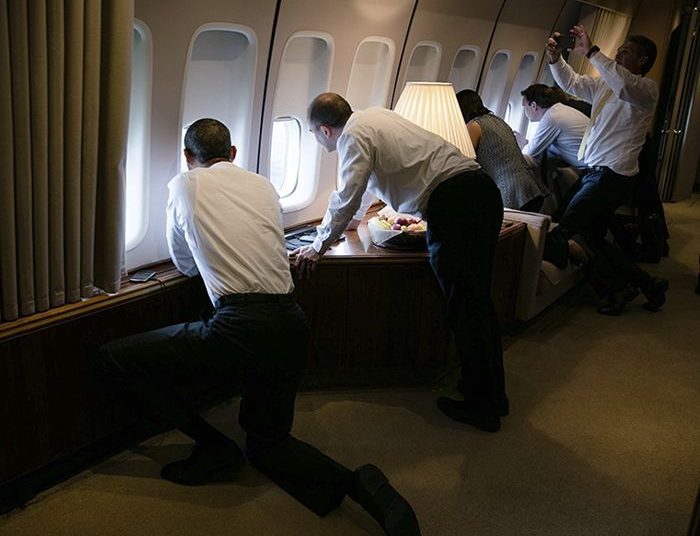 President Obama and members of his team look out the windows of Air Force One during the landing in Cuba. Photo: Pete Souza/The White House