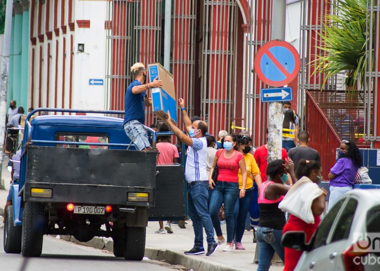 People carry merchandise purchased in freely convertible currency, in the Carlos III shopping mall, in Havana. Photo: Otmaro Rodríguez.