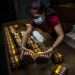 A worker wearing a protective mask packs cigars at the Partagás cigar factory in Havana, Cuba. Photo: Ramón Espinosa/AP/Archive.