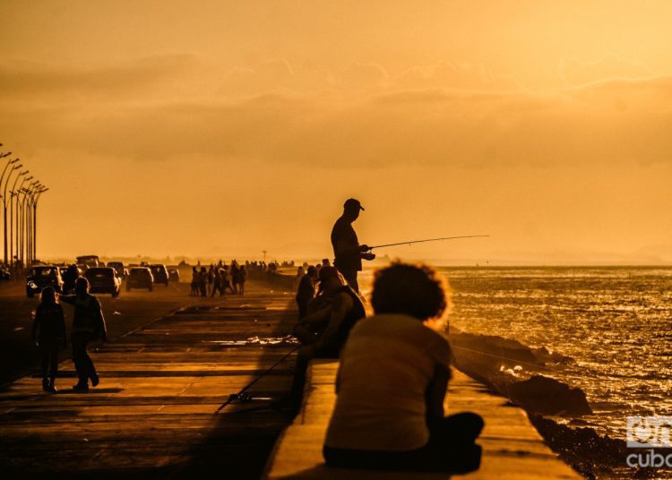 Cubans on the boardwalk in Havana. Economy in Cuba