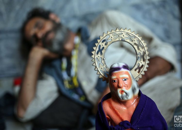 A pilgrim takes a nap next to an image of old San Lázaro. Photo: Alejandro Ernesto.