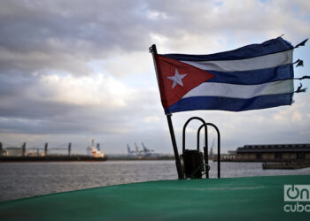 The Cuban flag flying on the roof of the old and battered small boat that makes the trip between Havana, Casablanca and Regla a hundred times a day. Photo: Alejandro Ernesto.