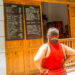 Woman looks at the prices of a MSME in Cuba