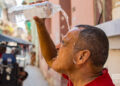 A man splashes himself with water to cool off from the intense summer heat. Photo: Otmaro Rodríguez.