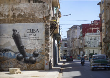 A car passes in front of graffiti on San Lázaro Street, in Havana (Cuba). Photo: EFE/Yander Zamora.