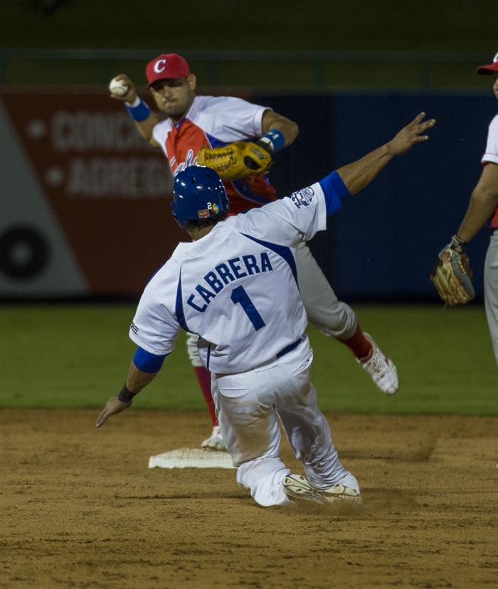 El nicaragüense Everth Cabrera (Abajo), se barre en segunda base ante la selección de Cuba. Foto: Jorge Torres / EFE.