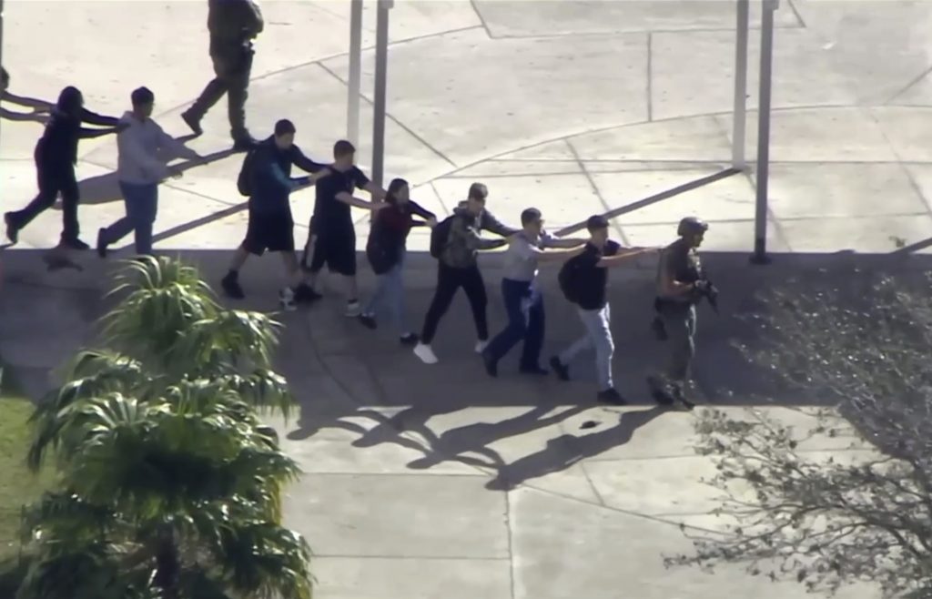 Captura de video cortesía de WPLG-TV, donde se observa a estudiantes de la escuela preparatoria Marjory Stoneman Douglas, mientras evacúan las instalaciones después del tiroteo. Foto: WPLG-TV vía AP.