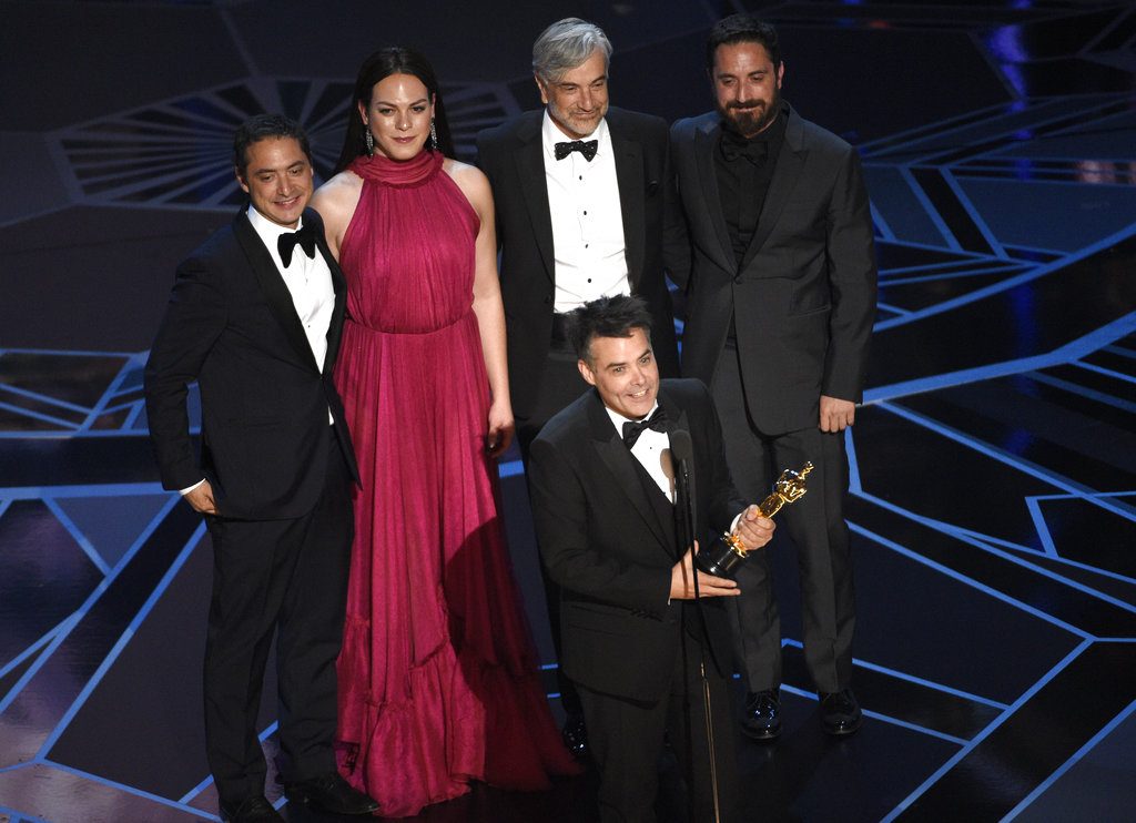 Sebastián Lelio, al frente, acepta el Oscar a la mejor película en lengua extranjera por "Una mujer fantástica" Lo acompañan, de izquierda a derecha, el productor Juan de Dios Larraín, la actriz Daniela Vega, el actor Francisco Reyes y el productor Pablo Larraín. Foto: Chris Pizzello/Invision/AP.