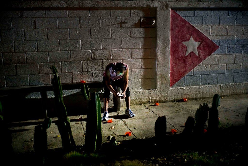 En esta imagen, tomada el 14 de abril de 2018, Lázaro Rodríguez, de 42 años, conecta su celular a red pública de internet en La Habana, Cuba. Lázaro, que estudió panadería y trabaja como mozo de mantenimiento, dijo que ha visto cambios muy positivos en la economía cubana en los últimos años y le gustaría ver que ese desarrollo continúa. (AP Foto/Ramón Espinosa)