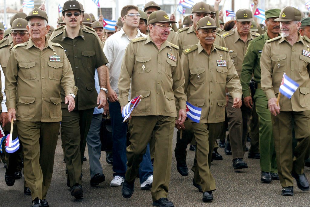 Raúl Castro, ministro de Defensa y hermano del entonces presidente Fidel Castro, y su hijo Alejandro Castro Espín (segundo por la izquierda), participan en una protesta contra el terrorismo en La Habana, el 17 de mayo de 2005. Detrás de la escena pública, Alejandro Castro, de 52 años, es una figura poderosa en el Ministerio del Interior que negoció en secreto la reanudación de las relaciones diplomáticas con el expresidente de Estados Unidos Barack Obama. (AP Foto/Jorge Rey, archivo)