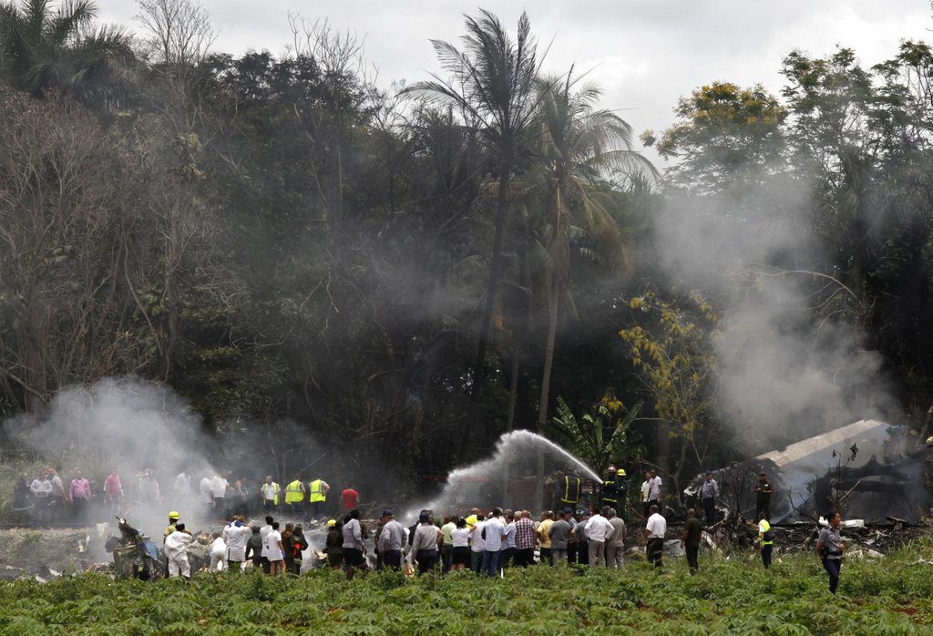 Los bomberos extinguen las llamas que envolvieron un Boeing 737 que cayó en un campo de yuca con 111 pasajeros a bordo en La Habana, Cuba. Foto: Enrique de la Osa/AP.