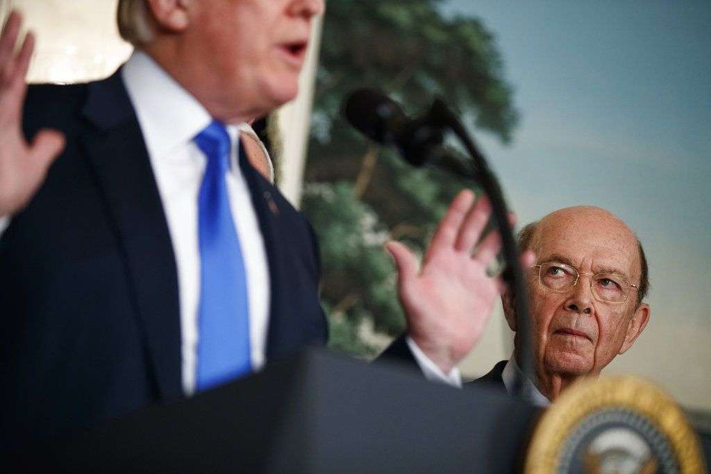 El secretario de Comercio, Wilbur Ross, escucha al presidente Donald Trump antes de firmar una iniciativa para imponer aranceles y restricciones de inversión a China, el 22 de marzo de 2018 en la Casa Blanca. Foto: Evan Vucci/AP.