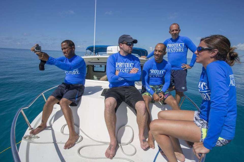 Hanzel Caballero, from the National Aquarium of Cuba, Shawn Garner, Senior Biologist at The Florida Aquarium, Pedro Chevalier, and Alexis Osoria from the National Aquarium of Cuba and Lauren DeLuca, from the Florida Aquarium, hang out together Sunday, August 21, 2016 as they wait for divers to bring up Staghorn coral from an underwater nursery to take to a lab in the Florida Keys. JOHN PENDYGRAFT Tampa Bay Times