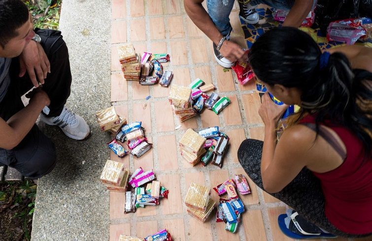 7 de junio de 2016. Liset junto a otros migrantes divide raciones de comida para los 4 o 5 días de camino a través de la selva. Los conducirá un coyote local. Foto: Lisette Poole.