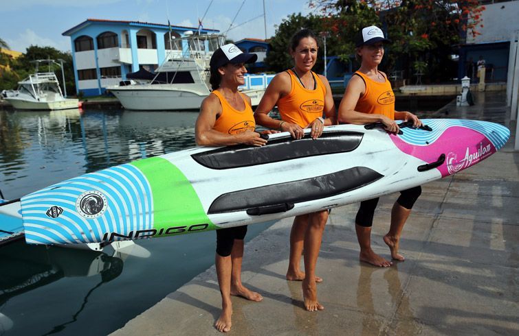 Las windsurfistas estadounidenses Aimee Spector (i), Cynthia Aguilar (c) y Karen Kim Figueroa (d), posan hoy en La Habana, poco antes de emprender una travesía sobre tabla desde la capital cubana hasta Cayo Hueso, Florida. Foto: Alejandro Ernesto / EFE. 