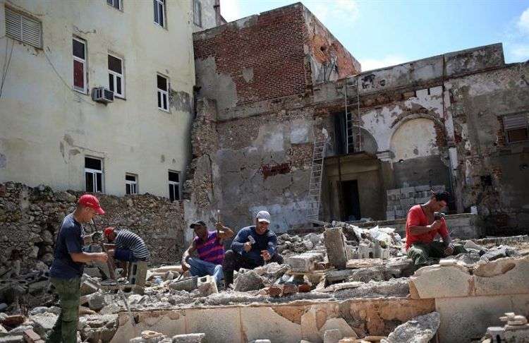 Obreros y militares trabajan en la rehabilitación de las zonas afectadas por Irma, el miércoles 13 de septiembre, en La Habana. Unas 4.288 viviendas resultaron dañadas en capital cubana, donde ocurrieron 157 derrumbes totales y 986 parciales, según reportes oficiales preliminares. Foto: Alejandro Ernesto / EFE.