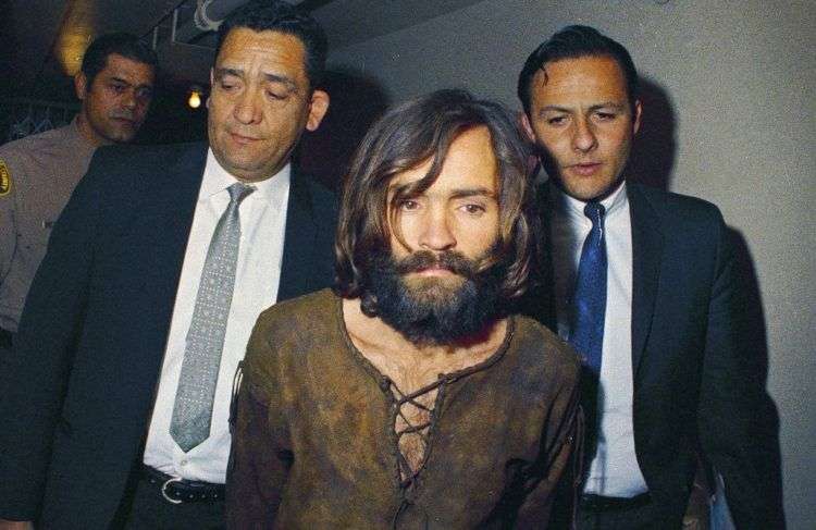 En esta imagen de archivo, tomada en 1969, Charles Manson es escoltado a una vista judicial relacionada con el asesinato de la actriz Sharon Tate. Según las autoridades, Manson, líder de un culto y autor intelectual de la muerte de Tate y de varias personas más, murió el 19 de noviembre de 2017 a los 83 años. Foto: AP.