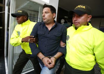 El cubano Raúl Gutiérrez conducido por dos policías tras su detención en Colombia en 2018, acusado de planear acciones terroristas. Foto: Fernando Vergara / AP / Archivo.