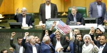 Legisladores iraníes queman dos papeles que representan una bandera de Estados Unidos y el acuerdo nuclear, mientras corean consignas contra Washington en el parlamento, en Teherán, el 9 de mayo de 2018. Foto: AP.