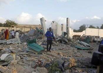 Soldados caminan entre vehículos destrozados y restos tras un doble ataque en la capital de Somalia, Mogadiscio. Foto: Farah Abdi Warsameh / AP.