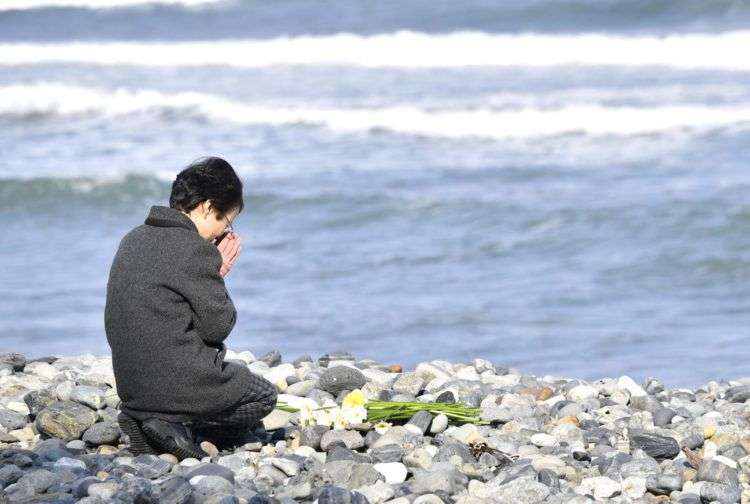 Una mujer reza hacia el mar en memoria de las víctimas del tsunami que hace 7 años cobró la vida de al menos 18,000 personas en Kesennuma, Japón. Foto: Iori Sagisawa / Kyodo News via AP.