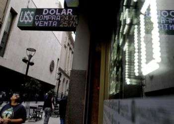 Una mujer observa una pantalla con las tasas de cambio entre el peso argentino y el dólar estadounidense en Buenos Aires, el martes 15 de mayo de 2018. Foto: Natacha Pisarenko / AP.