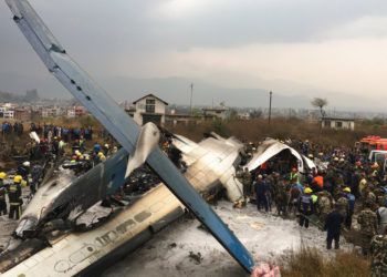 Rescatistas nepalíes junto a un avión de pasajeros de Bangladesh estrellado en el aeropuerto de Katmandú, en Nepal. Foto: Niranjan Shreshta / AP.