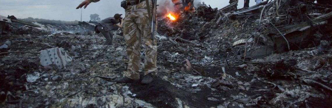 Varias personas caminan entre los restos del vuelo MH17, derribado cerca de la localidad de Grabovo, Ucrania. Foto: Dmitry Lovetsky / AP.