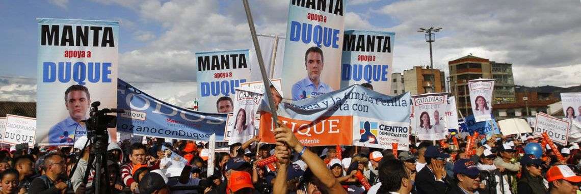 Un simpatizante del candidato presidencial Iván Duque ondea una bandera colombiana durante un evento de campaña en Soacha, a las afueras de Bogotá, el 12 de mayo de 2018. Foto: Fernando Vergara / AP.