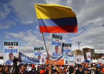 Un simpatizante del candidato presidencial Iván Duque ondea una bandera colombiana durante un evento de campaña en Soacha, a las afueras de Bogotá, el 12 de mayo de 2018. Foto: Fernando Vergara / AP.