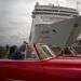 Turistas que recorren La Habana pasan por delante de un crucero atracado en el puerto de la capital de Cuba. Foto: Ramón Espinosa / AP.