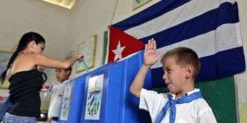 Un niño saluda mientras una mujer vota en las elecciones en Cuba. Foto: Alejandro Ernesto / EFE / Archivo.