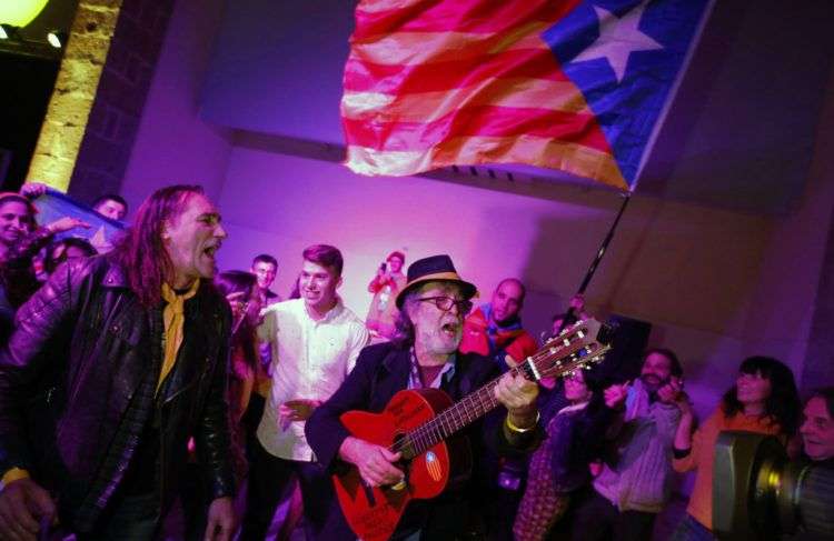 Partidarios de la independencia catalana celebran en la sede de la organización de bases Assemblea Nacional Catalana los resultados de las elecciones regionales en Barcelona. Foto: Emilio Morenatti / AP.