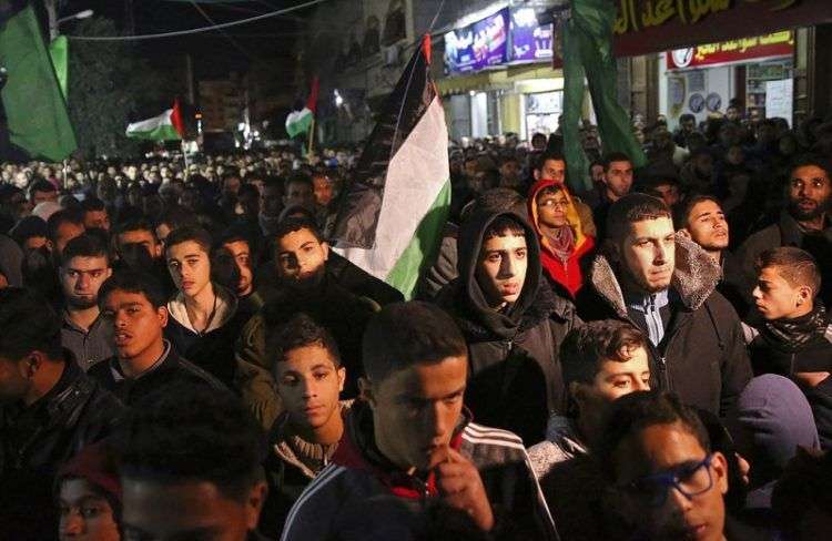 Familiares de Jamal Afaneh, un joven palestino de 15 años, velan su cuerpo en su casa durante su funeral, en el campo de refugiados de Rafah, en el sur de la Franja de Gaza, el 13 de mayo de 2018. Afaneh fue asesinado por soldados israelíes durante una protesta en la frontera. Foto: Khalil Hamra / AP.